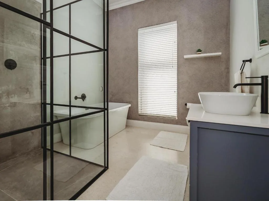 Modern bathroom with walk-in shower, freestanding tub, and dark vanity