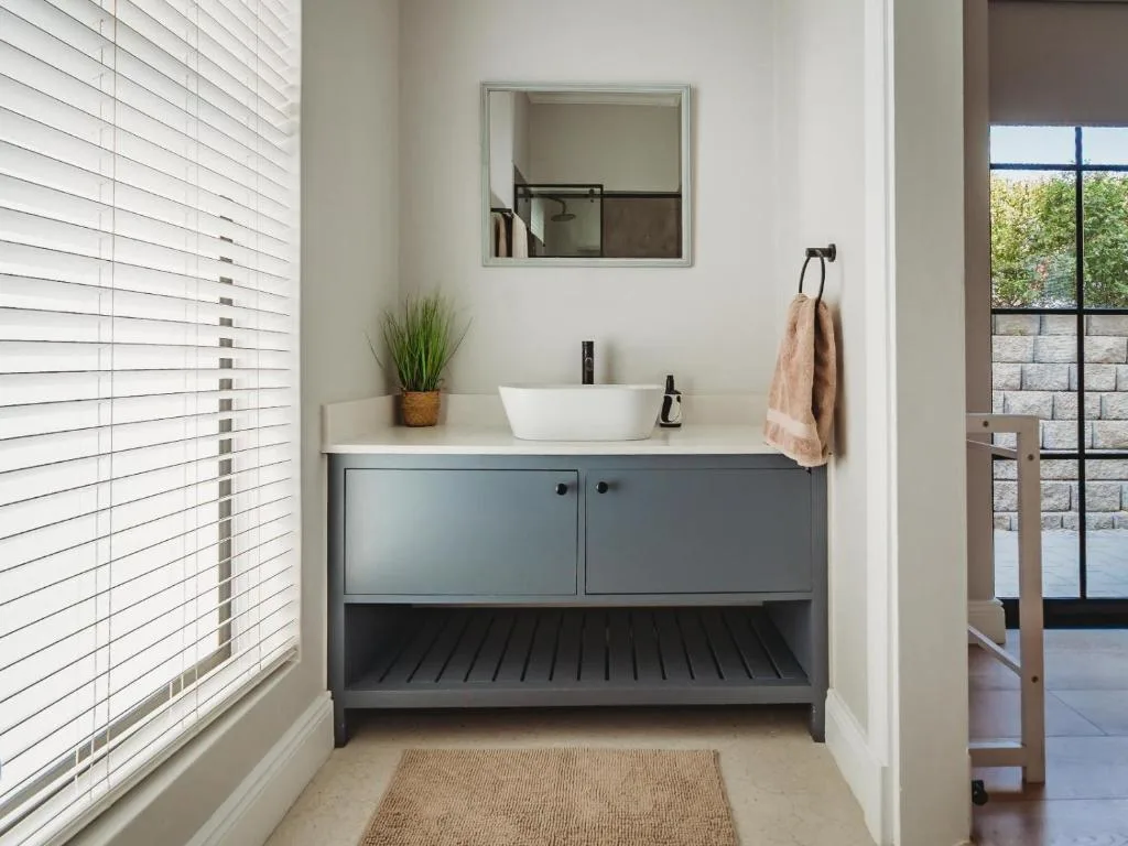 Modern bathroom vanity with white basin sink and gray cabinetry