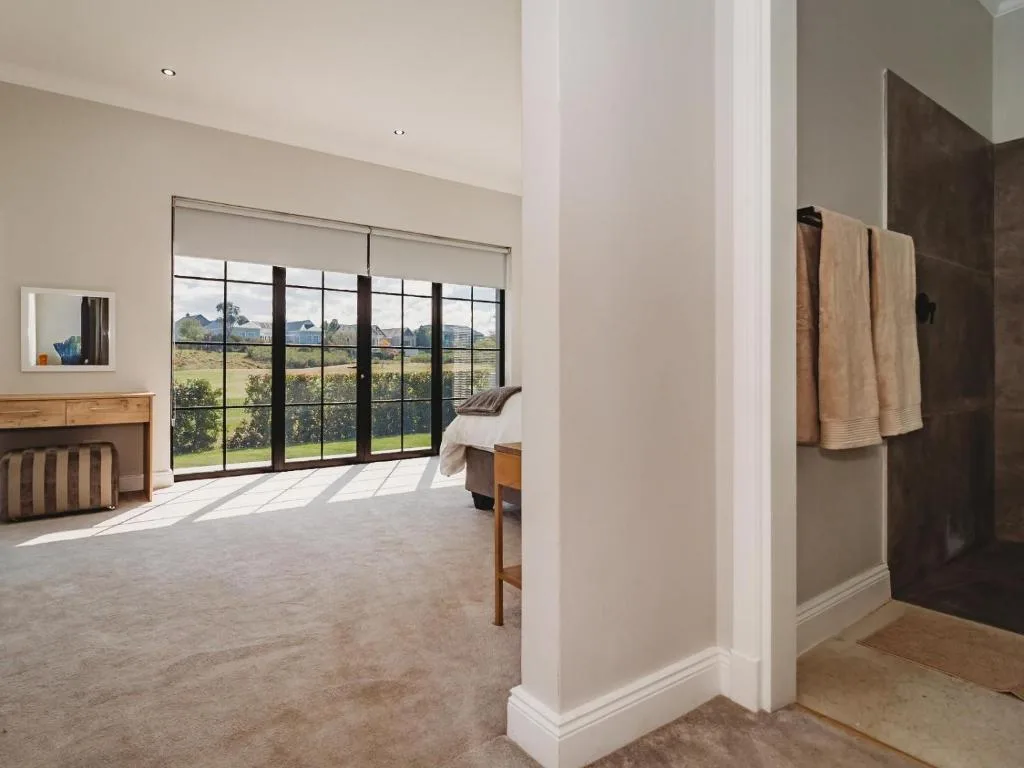 Spacious bedroom with large windows overlooking pastoral landscape views