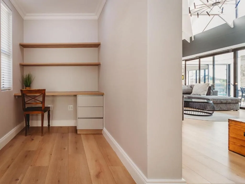 Modern home office nook with wooden shelves, desk, and chair
