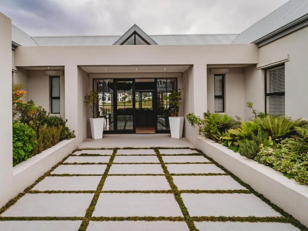 Modern white house entrance with landscaped courtyard and glass doors
