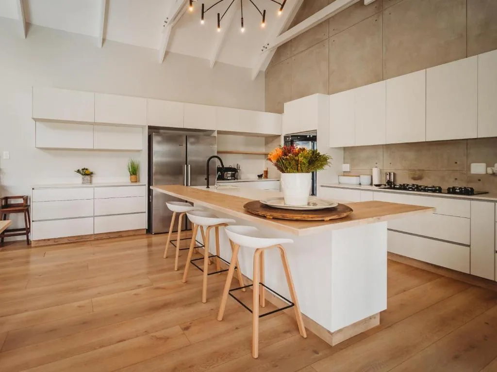 Modern kitchen with white cabinetry, wood island, stainless steel appliances