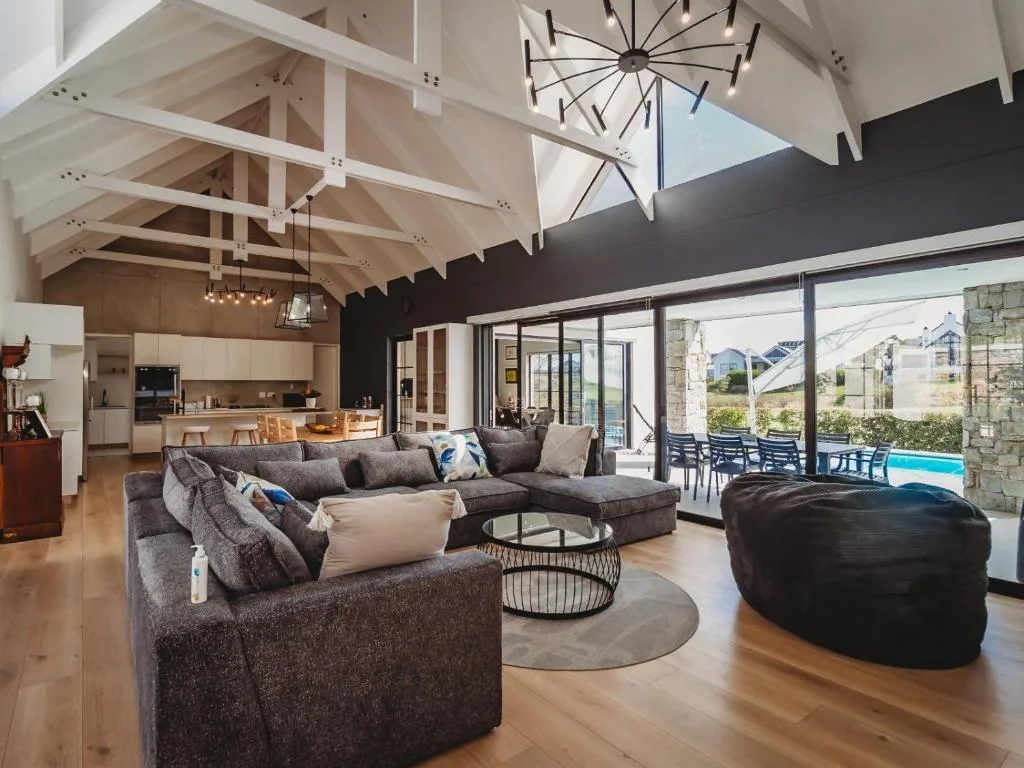 Spacious open-plan lounge with grey corner sofa and vaulted ceiling