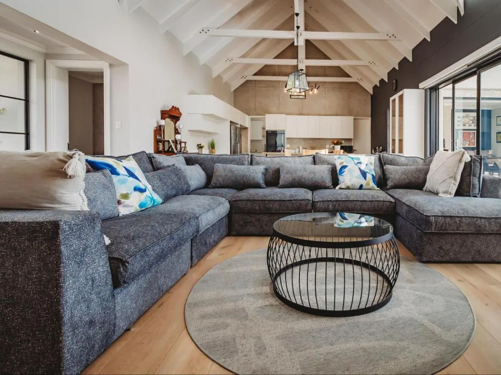 Spacious open-plan lounge with large grey sectional sofa and modern coffee table