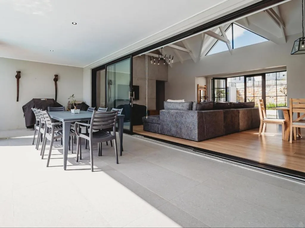 Open-plan living space with modern sofa, dining table, and skylight windows