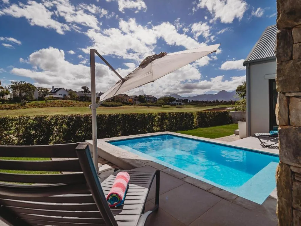 Swimming pool with cantilever umbrella and mountain views beyond
