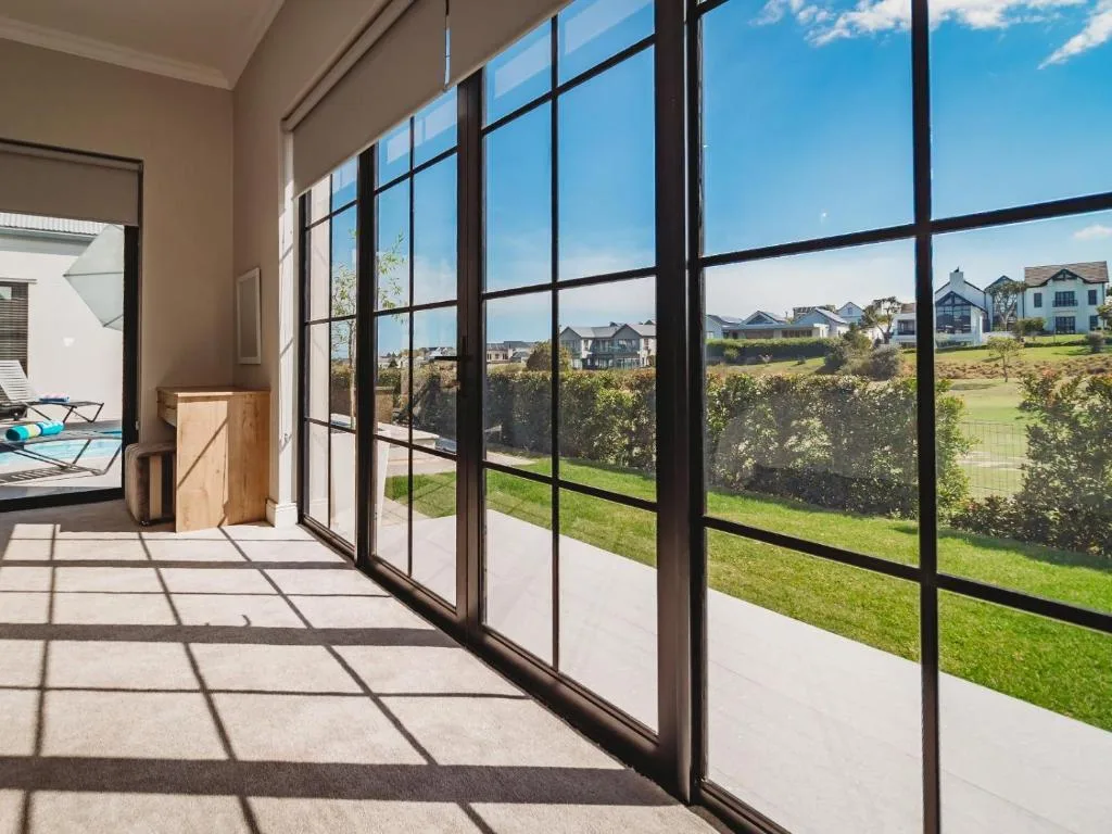 Scenic suburban landscape with green grounds and residential properties visible through large windows