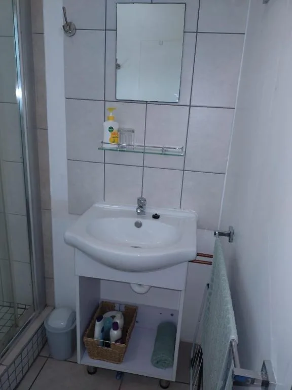 Clean white bathroom vanity with mirror and tiled walls