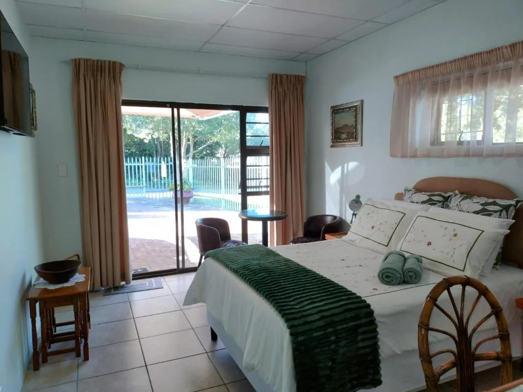 Spacious bedroom with queen bed, patio doors overlooking pool area