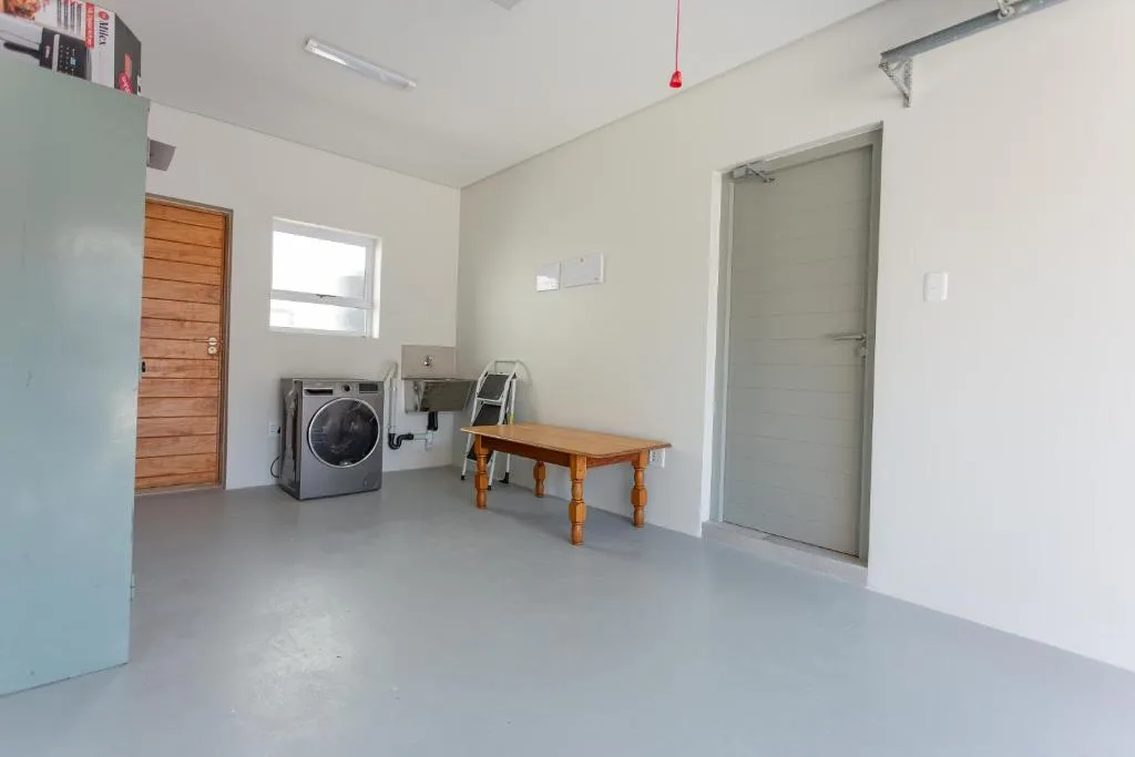Utility room with washing machine, wooden bench, and storage shelves