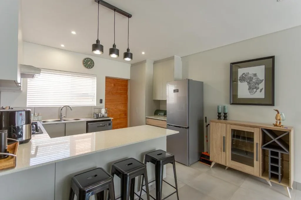 Modern kitchen with island counter, stainless appliances, pendant lights overhead