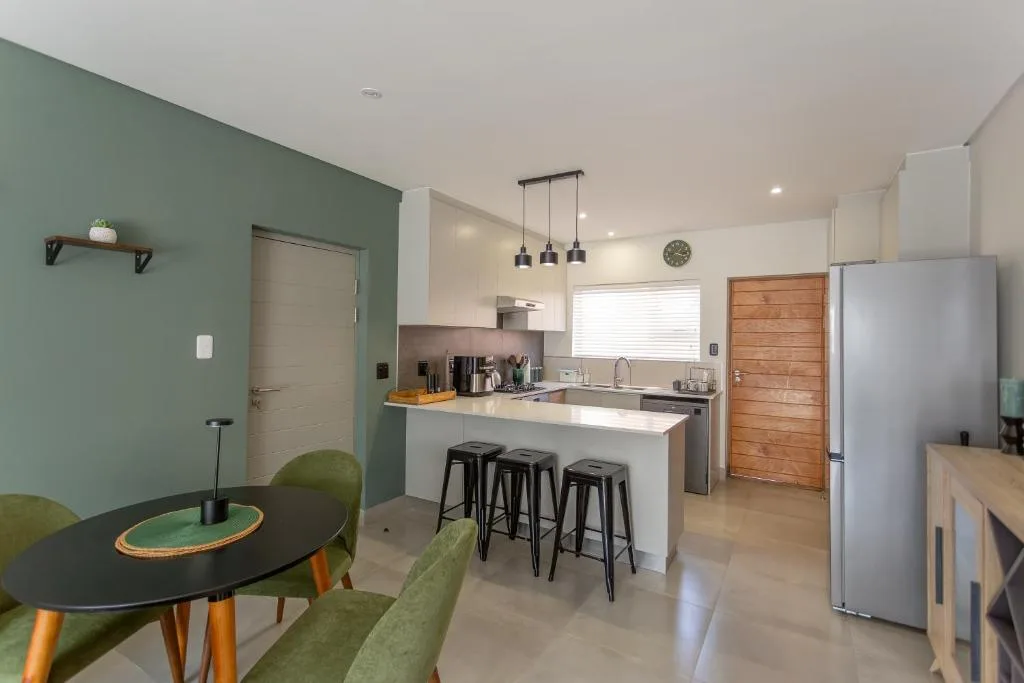 Modern kitchen with white cabinetry, stainless steel appliances, island seating