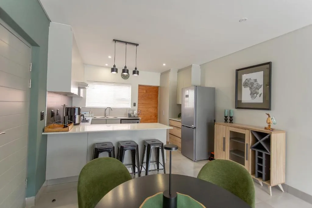 Modern kitchen with white cabinetry, island seating, stainless steel appliances