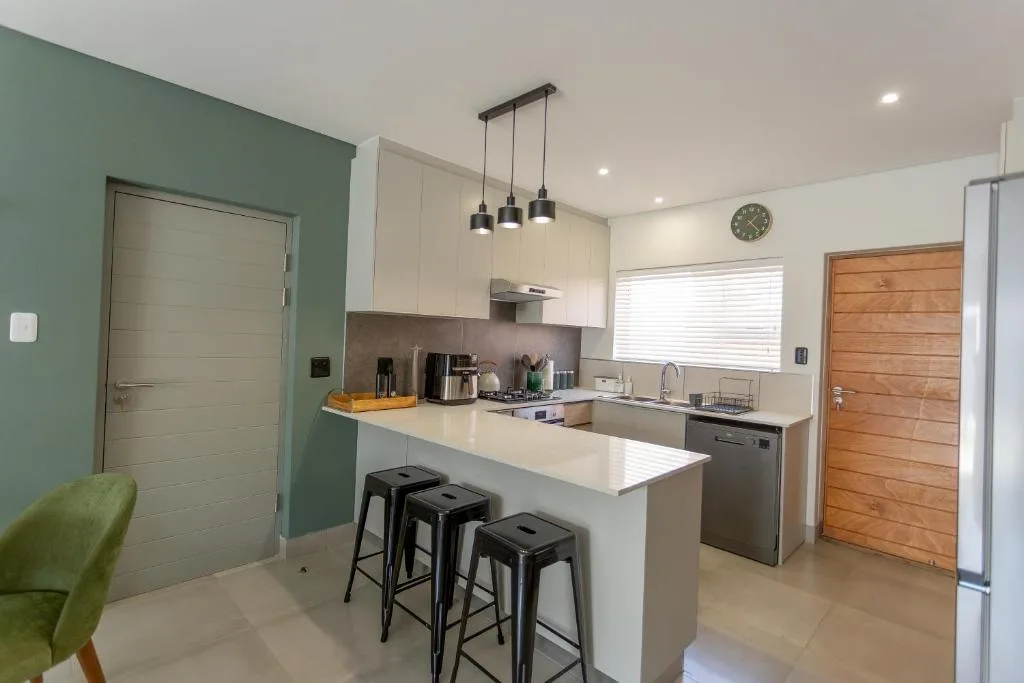 Modern kitchen with white cabinetry, island counter, and pendant lighting
