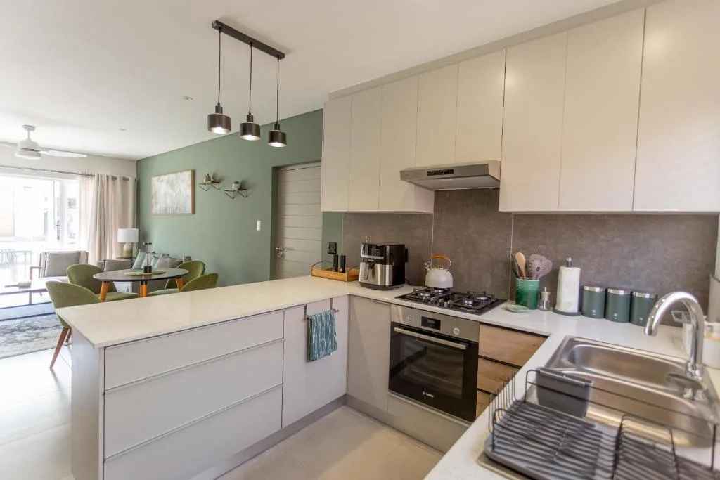 Modern kitchen with white cabinetry, stainless steel appliances, and pendant lighting