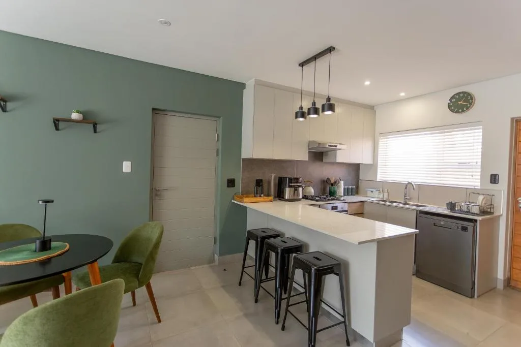 Modern kitchen with white cabinetry, island seating, and pendant lights overhead