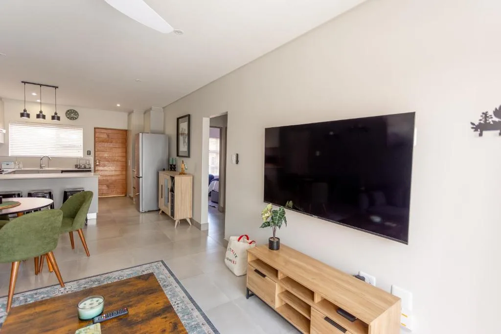 Modern living room with wall-mounted TV and wooden entertainment unit