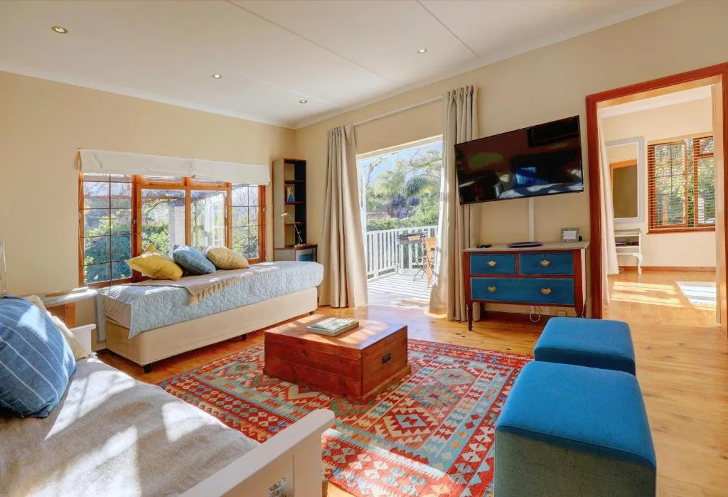 Spacious bedroom with bed, deck views, TV, and colorful furnishings