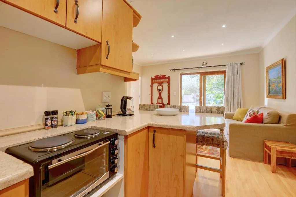 Bright kitchen with wooden cabinetry, stove, and open-plan dining lounge area