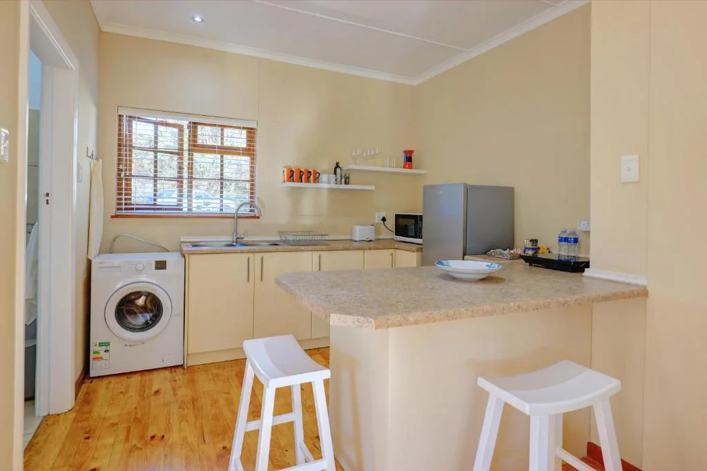 Bright kitchen with cream cabinetry, island counter, and stainless steel appliances