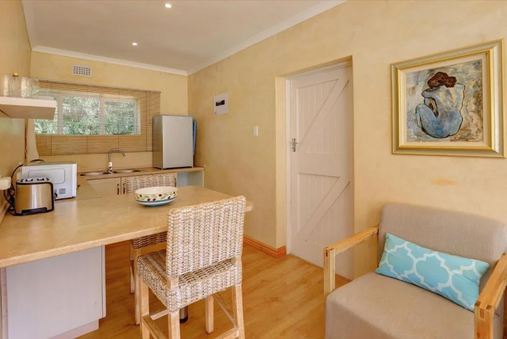 Compact kitchen with counter seating, appliances, and yellow walls