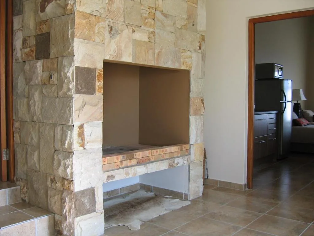 Stone fireplace with brick hearth in modern lounge interior space