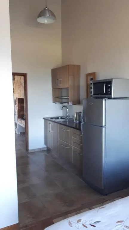 Modern kitchenette with stainless steel appliances and dark countertops