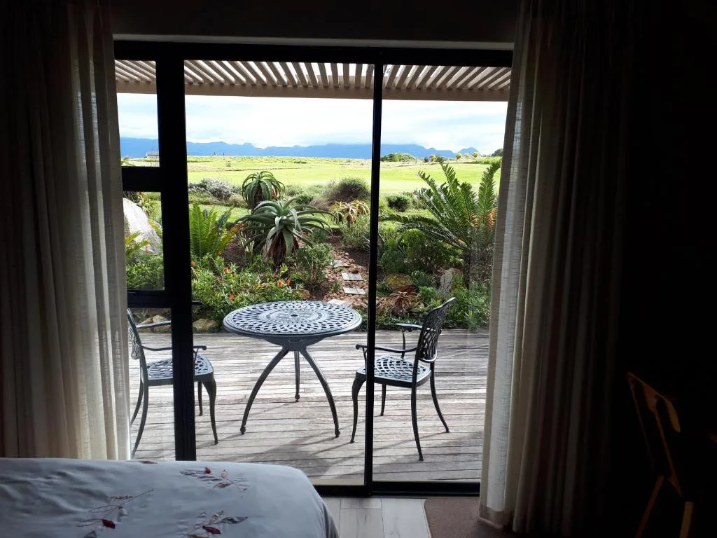 Scenic lagoon and mountain vista framed by deck doors and garden