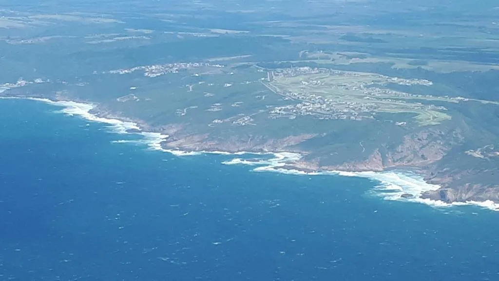 Aerial view of dramatic coastal cliffs and turquoise ocean waters along Garden Route