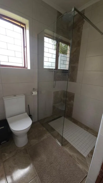 Modern bathroom with glass shower enclosure and white toilet fixture