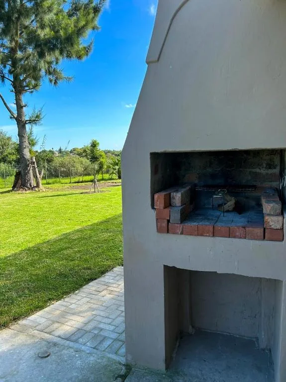 Built-in brick braai area on patio with garden views beyond