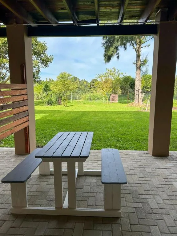 Covered patio with picnic table overlooking spacious green garden lawn