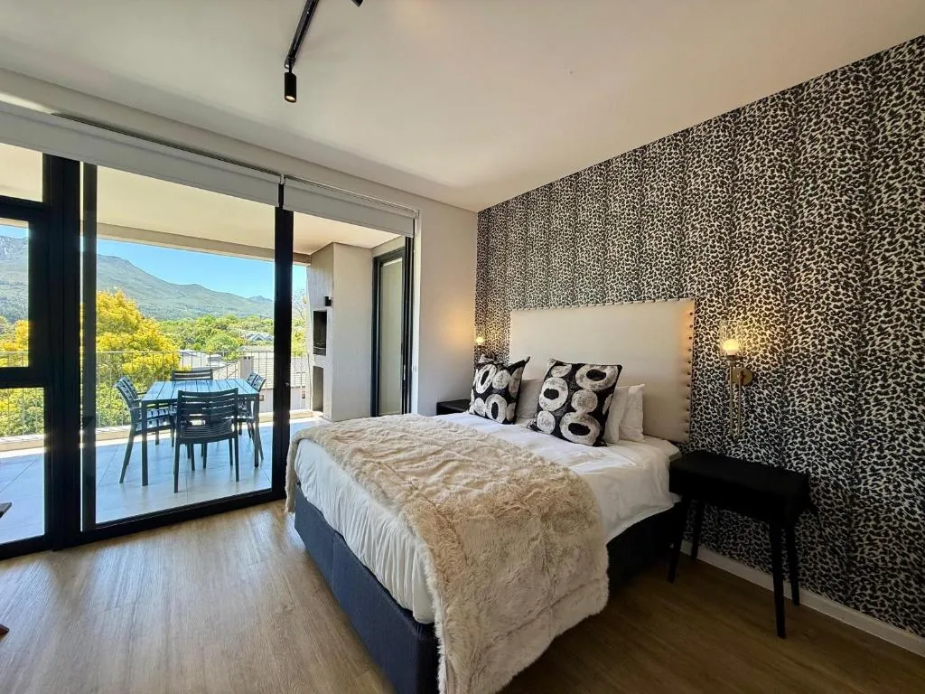 Spacious bedroom with mountain views through sliding glass doors to deck