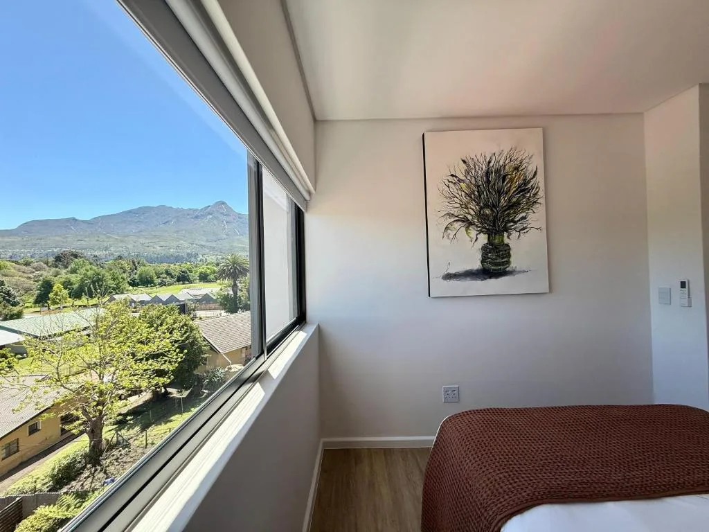 Bedroom with mountain views through large window and modern wall art