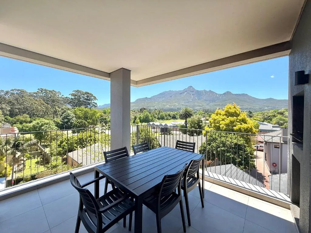 Covered deck with dining table overlooking mountain and town views