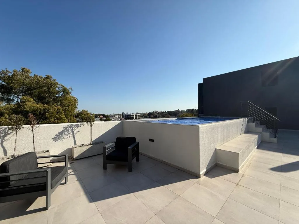 Rooftop terrace with pool, seating, and scenic landscape views