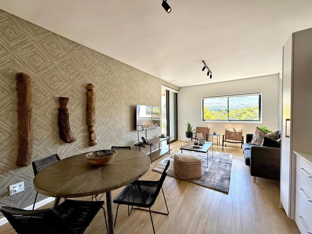 Modern lounge with dining area, featuring contemporary furniture and mountain views through large windows