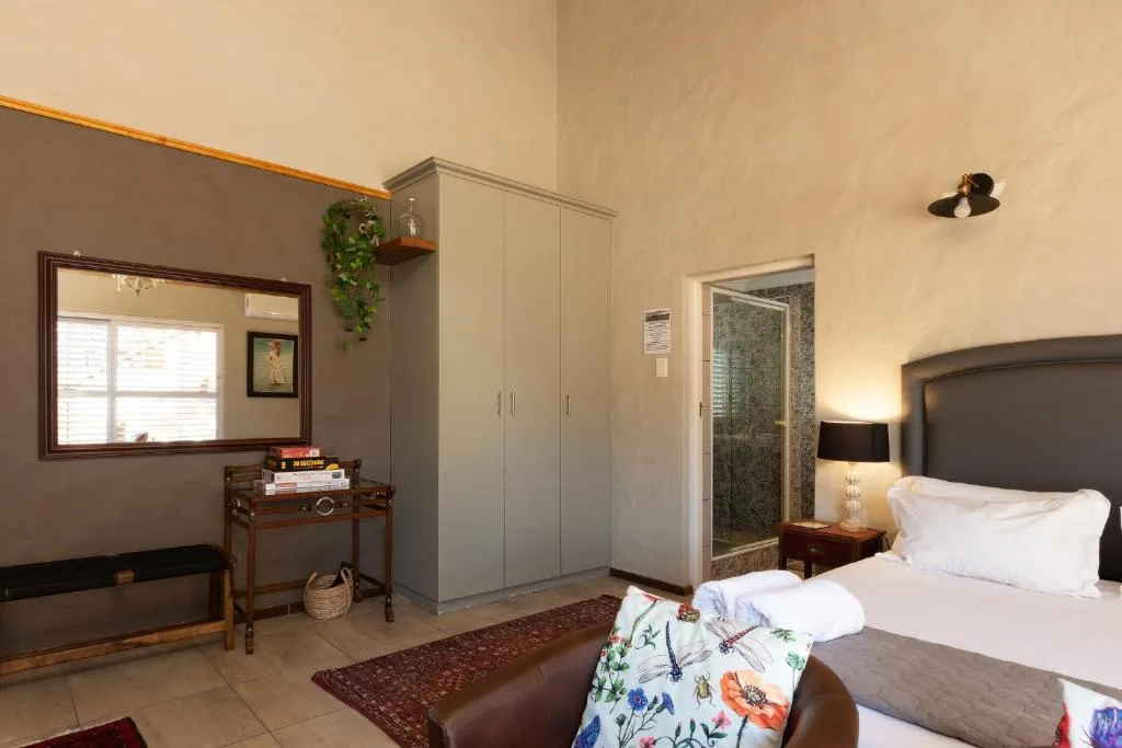 Spacious bedroom with queen bed, wardrobe, and ensuite bathroom entrance