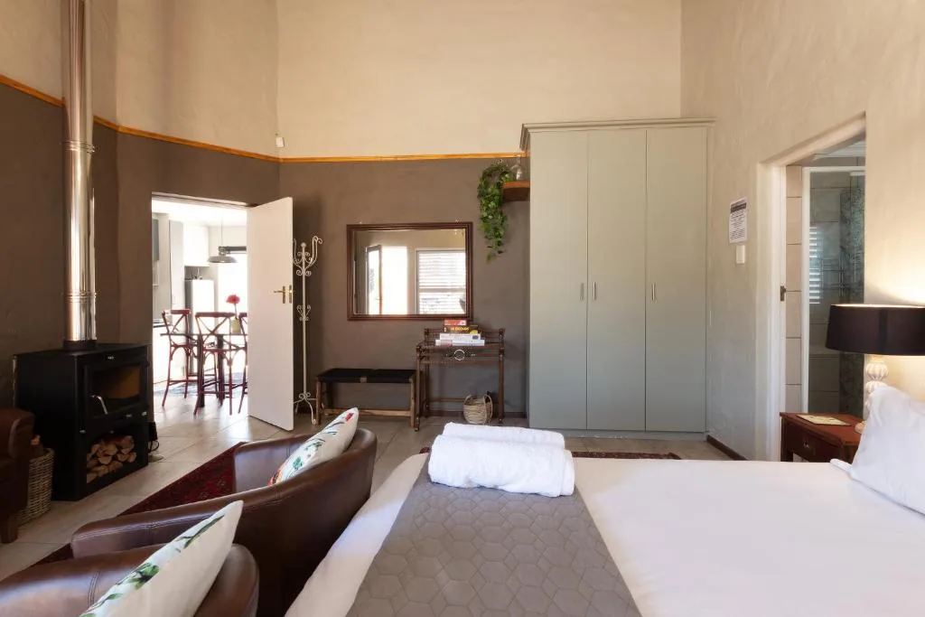 Spacious bedroom with double beds, fireplace, and modern wardrobe storage