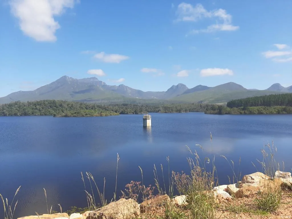 Scenic mountain lake landscape with forested shoreline under blue sky