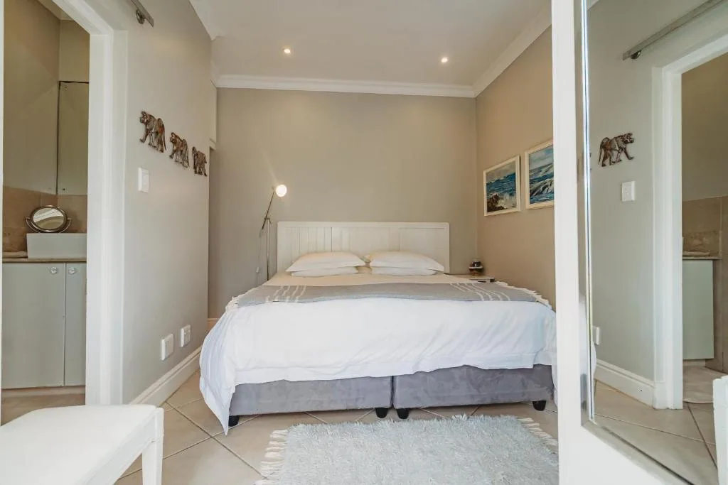 Spacious bedroom with white headboard bed and en-suite bathroom access