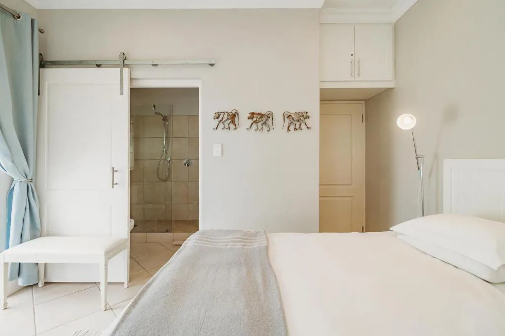 Bright modern bedroom with en-suite bathroom and elephant wall art decor