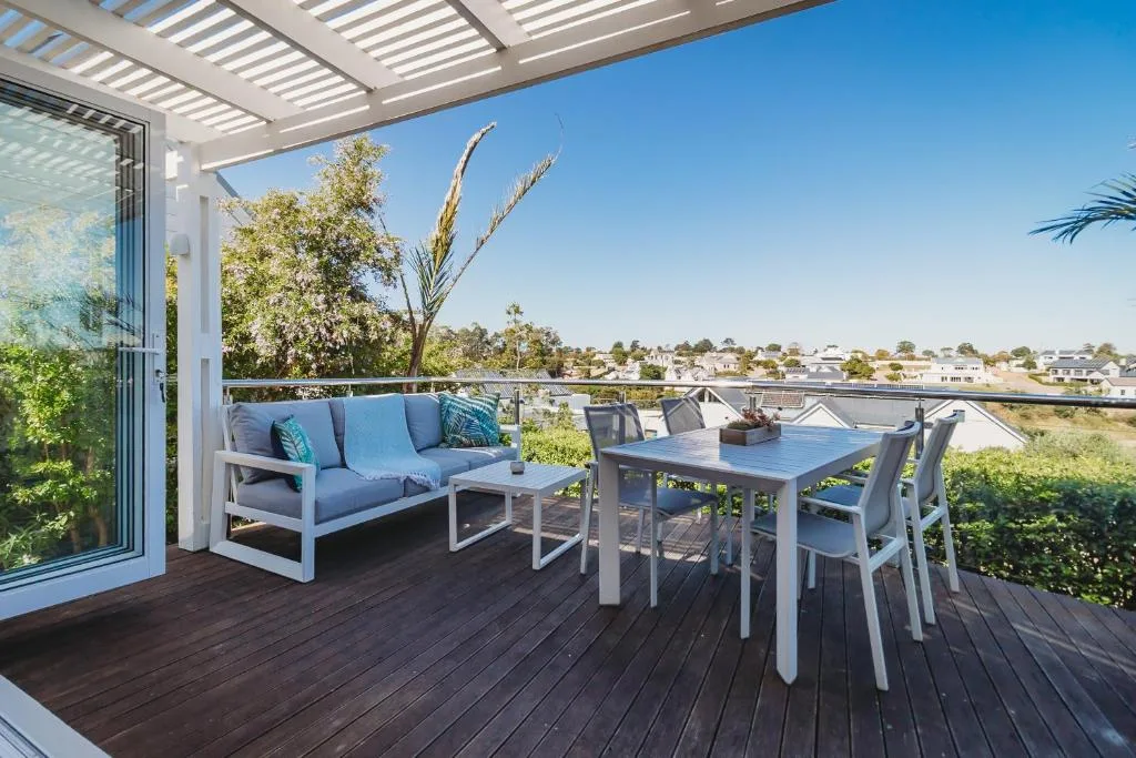 Spacious rooftop deck with lounge seating, dining table, and panoramic town views