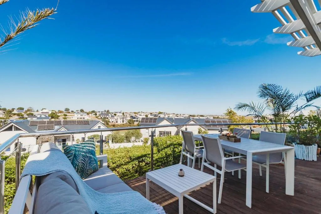 Spacious rooftop deck with lounge seating and dining table overlooking town