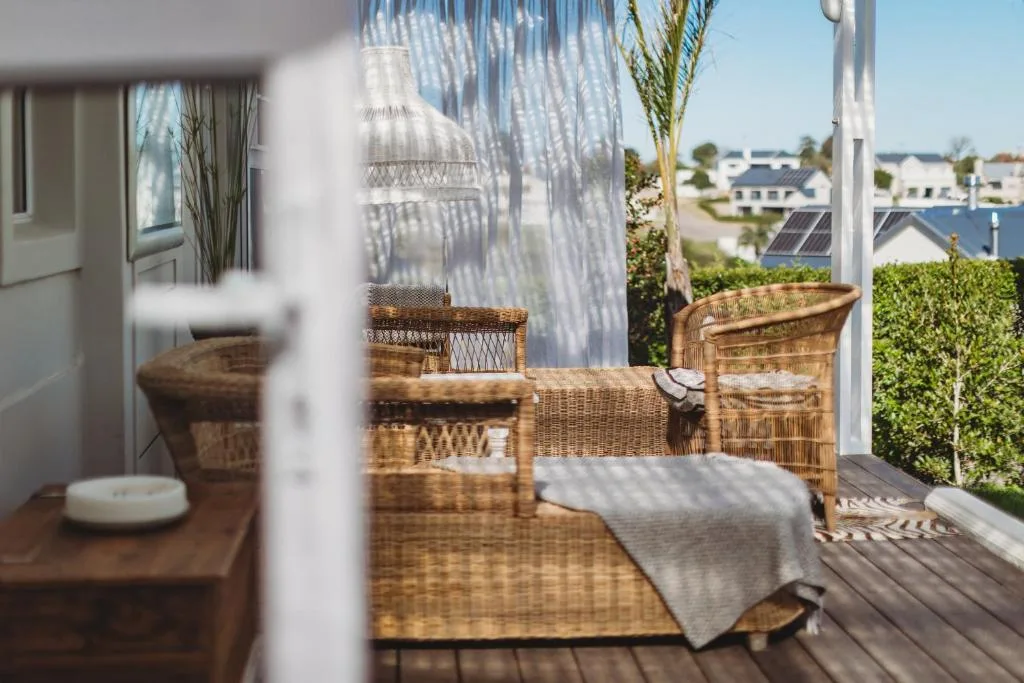 Wicker seating area on wooden deck overlooking residential neighborhood