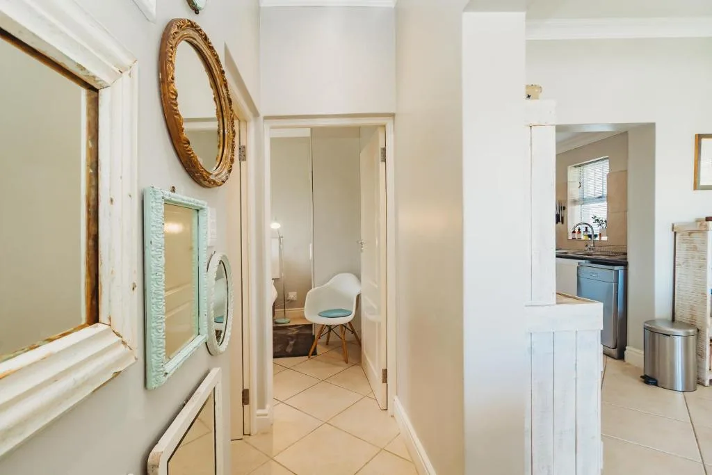 Hallway with decorative mirror and access to kitchen and bedroom areas
