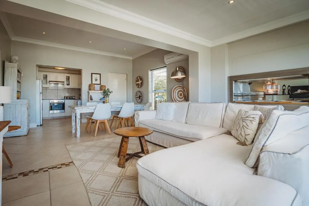 Spacious open-plan lounge with cream sofas, wooden accents, and modern decor