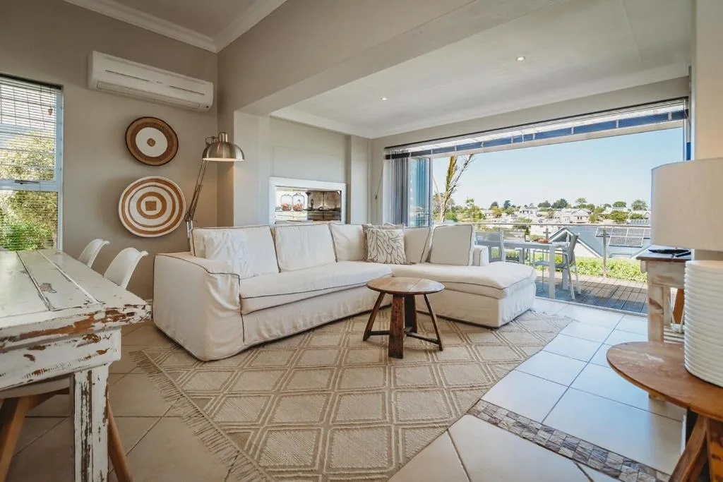 Spacious lounge with cream sectional sofa overlooking garden route views