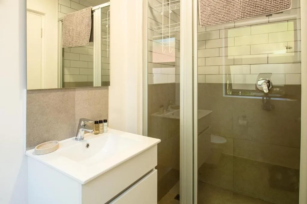 Modern bathroom with vanity, mirror, and walk-in shower enclosure