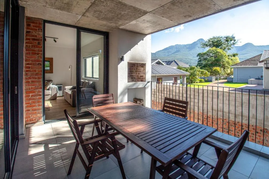 Outdoor patio with dining table overlooking mountain views and gardens